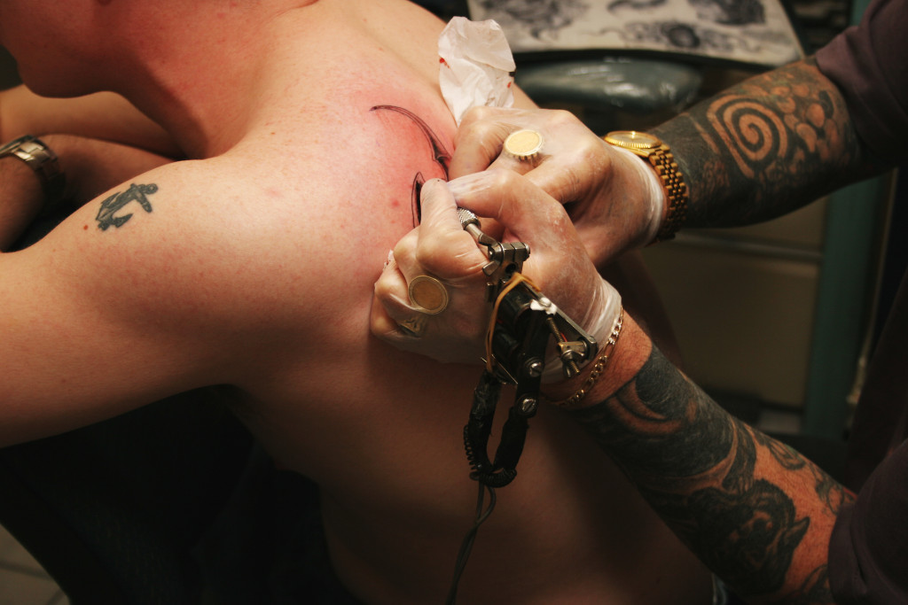 a person getting tattooed on his back