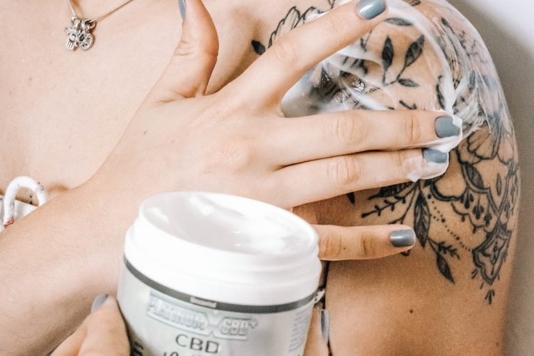 woman putting cream on her tattoo